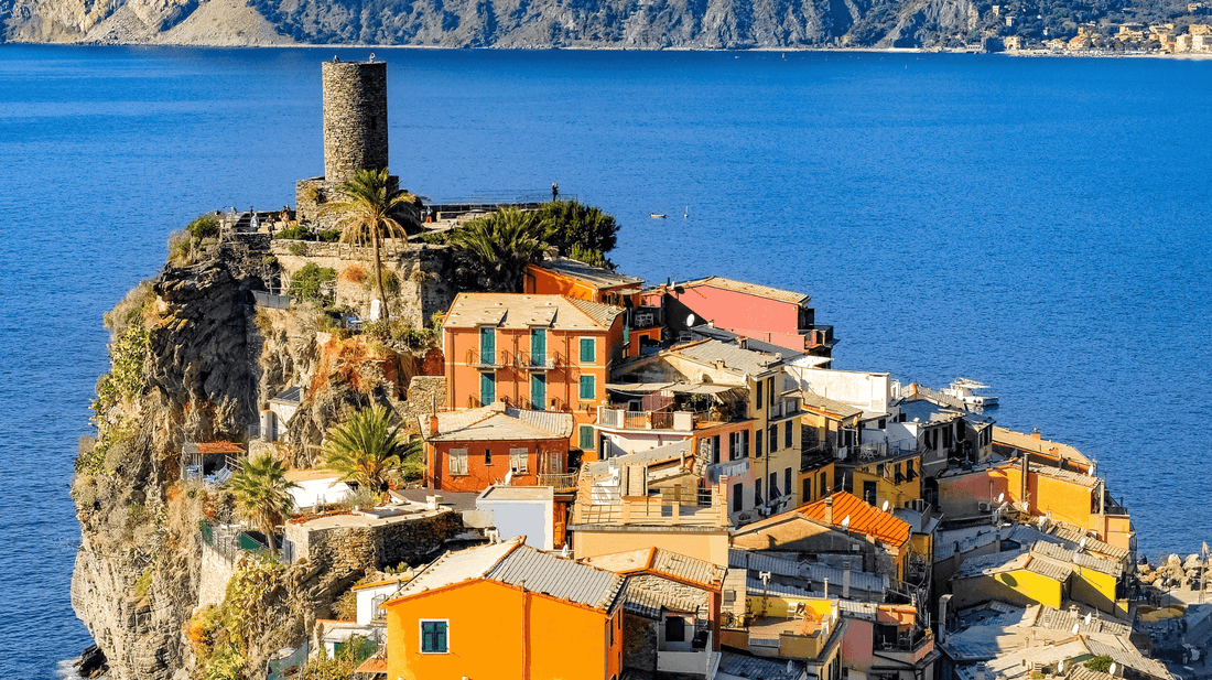 Colourful houses in Blue Zone Sardinia, Italy with bright blue ocean in background 