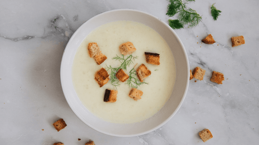 Bowl of creamy vegetable soup topped with croutons and fresh herbs, made with organic vegetables and organic food delivery in Brisbane