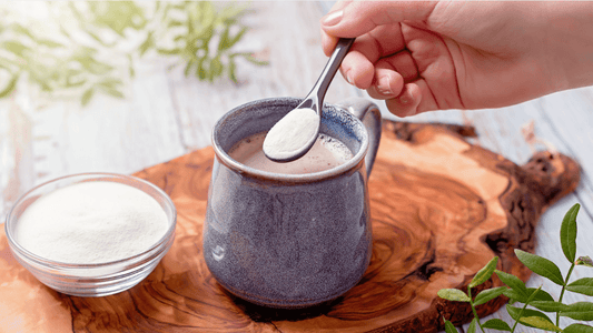 Person adding grass-fed collagen peptides to morning coffee.