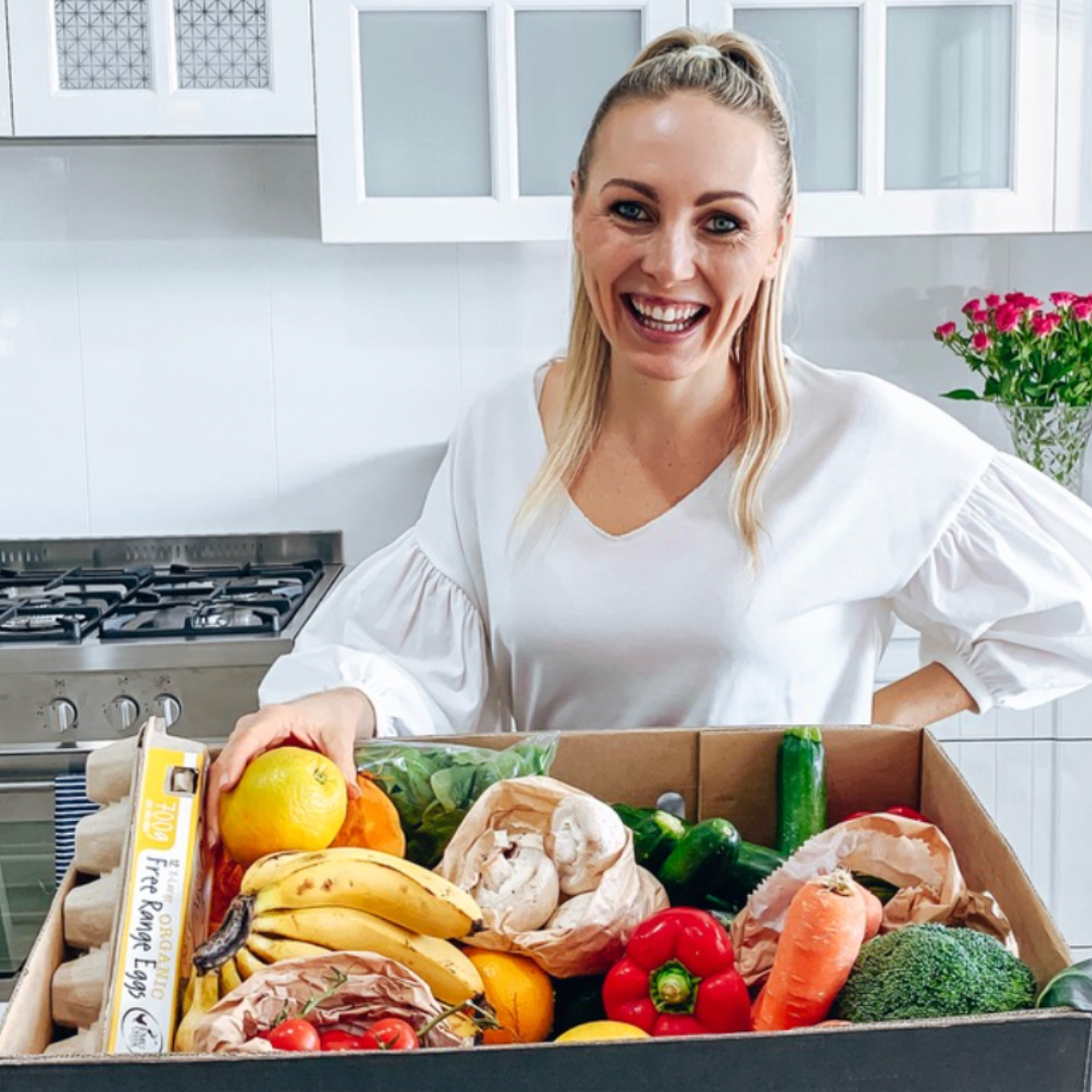 nutritionist Casey-Lee Lyons standing in front of organic grocery box 