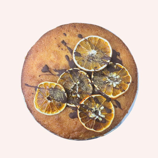 Round cake with dried orange slices and chocolate drizzle handmade and organic